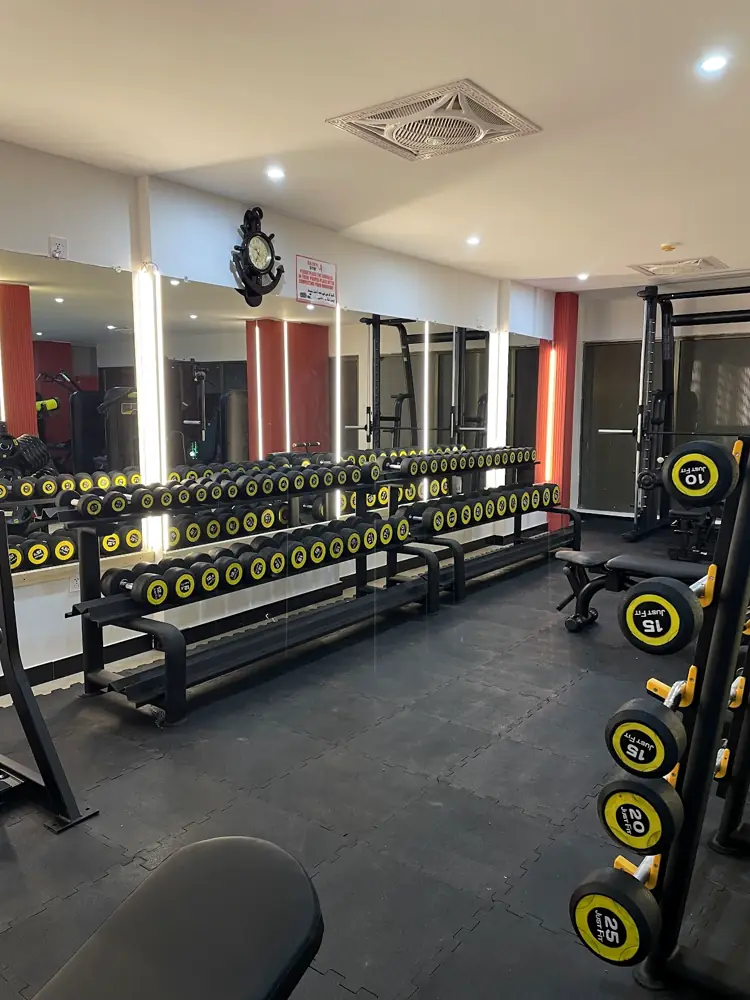 Dumbbell rack between the red pillars at Zain's Gym